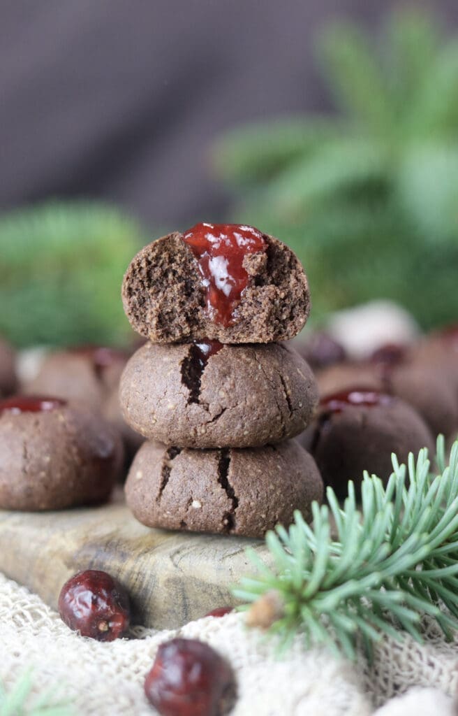 Gluten free jam filled buckwheat cookies stacked on top of eachother, half of cookie with jam on top.